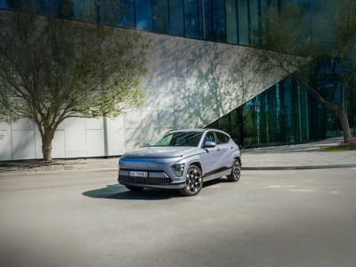 KONA Electric parkert ved et moderne bygg. Foto.