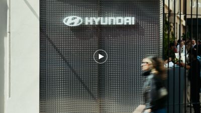 Hyundai exhibition entrance at Milan Design Week with visitors passing logo facade