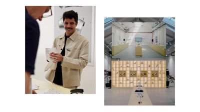 Person at Hyundai exhibition desk handing brochure to visitor at Milan Design Week