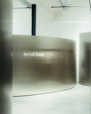 Hyundai exhibition space with curved metal installation and “Art of Steel” text on wall