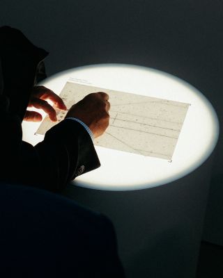 Person interacting with illuminated document display in Hyundai workshop at Milan Design Week