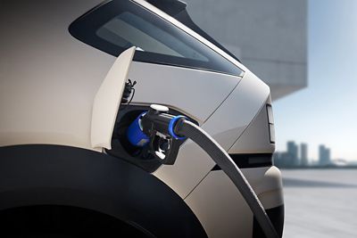 Hyundai NEXO with an hydrogen filling nozzle plugged into the side filling port.	