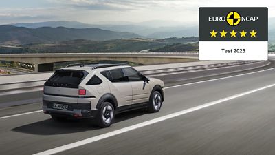 A Hyundai NEXO drives on a highway near mountainous scenery, showcasing its Euro NCAP 5-star safety rating for 2025.