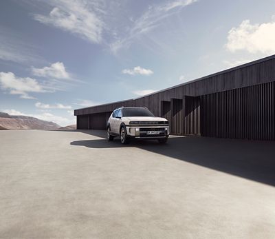 The all-new Hyundai NEXO pictured from the front parked in front of a modern garage.