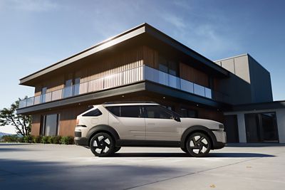 Modern house with a Hyundai NEXO parked in the driveway under a clear blue sky.