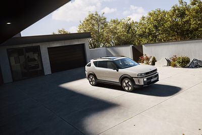 The all-new Hyundai NEXO seen from the side, parked in a wide driveway in front of a modern house.