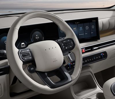 Close up view of the steering wheel and curved touch screen inside the Hyundai NEXO