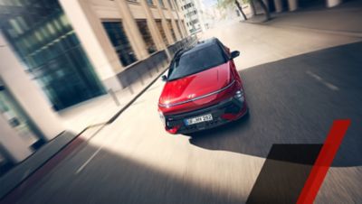 The Hyundai KONA N Line seen front the front driving down a city street.