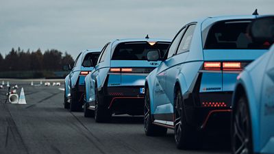Multiple Hyundai IONIQ 5 N vehicles lined up on a test track, viewed from the rear.