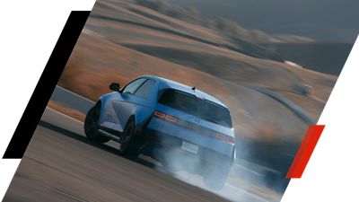 The Hyundai IONIQ 5 N billowing smoke from its tyres while drifting a curve.