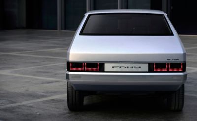 Achteraanzicht Hyundai Pony EV Heritage tegen donkere achtergrond.