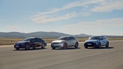 Die Hyundai Modelle IONIQ 6, IONIQ 5 und IONIQ 5 N fahren gestaffelt auf einer breiten Asphaltpiste.