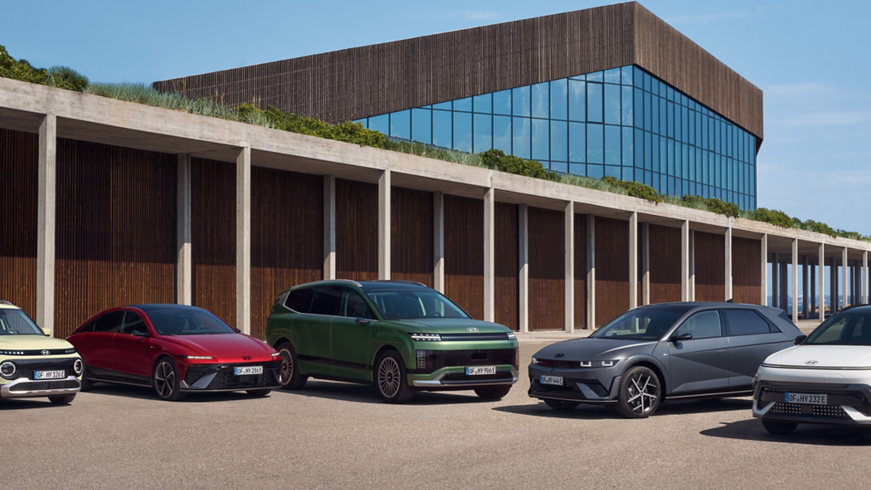 Hyundai electric vehicle lineup featuring Hyundai INSTER, IONIQ 6, IONIQ 9, IONIQ 5 and KONA Electric outside a modern building.