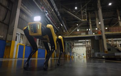 Boston Dynamics robots Spot and Atlas, facing a Hyundai NEXO hydrogen fuel cell vehicle.