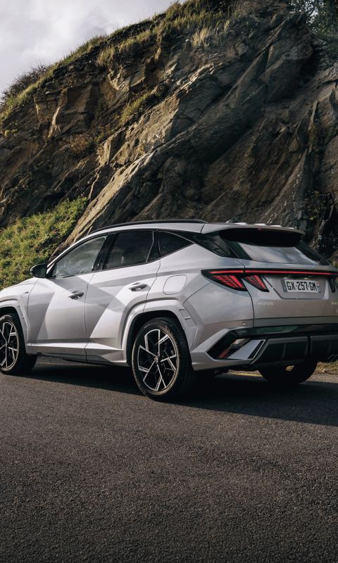 Vue de trois quarts arrière de TUCSON HEV devant une montagne
