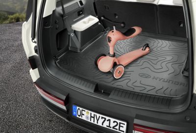 Une trottinette d'enfant sur le revêtement imperméable du coffre du Hyundai SANTA FE.