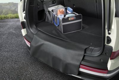 Een doos in de kofferbak van de SANTA FE, met een bumperflap voor de kofferbakmat die de nummerplaat afdekt.