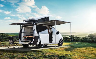 Hyundai STARIA Camper Concept recreational vehicle with pop-up roof, awning and rear hatch open.