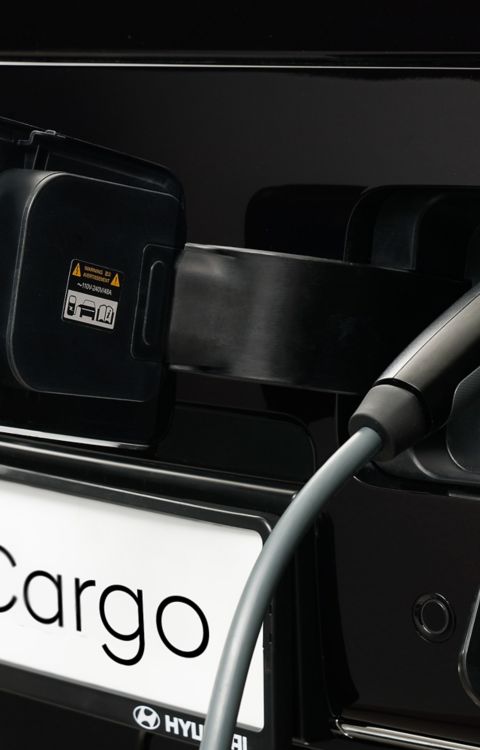 Detailopname van laadkabel in de laadpoort van de Hyundai STARIA Cargo.