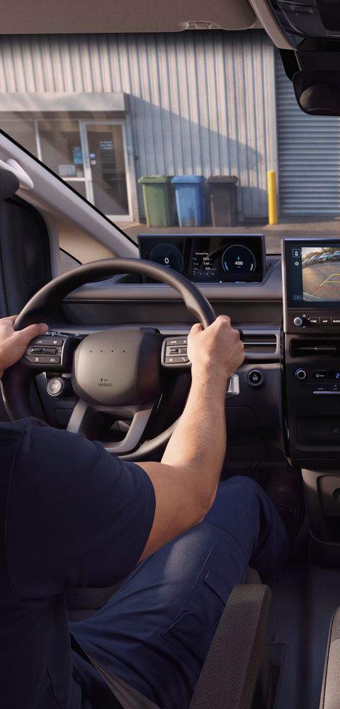 A man in the driving seat of Hyundai STARIA Cargo using Rear View Camera.