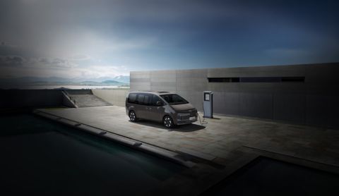 Hyundai STARIA Electric connected to an EV charger outdoors, highlighting convenient charging access.