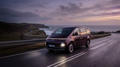 Hyundai STARIA Electric kjørende på en kystvai. Foto.
