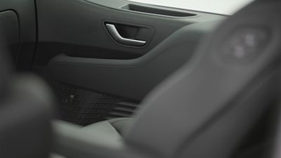 Close-up of the STARIA Electric interior door panel with integrated Bose sound system.