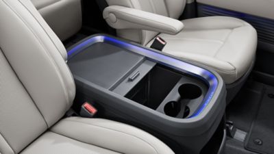 Hyundai STARIA Electric front seating area with multifunction center console and adjustable armrests.