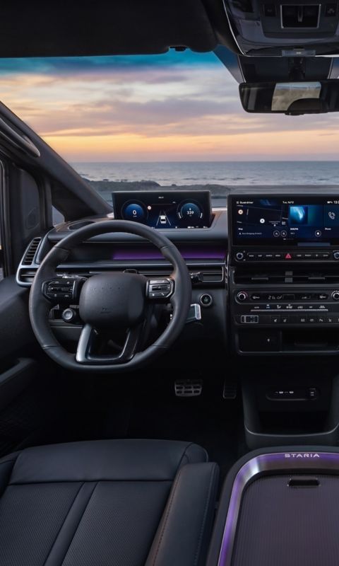 Full Hyundai STARIA Electric interior view showing driver and passenger area at sunset.