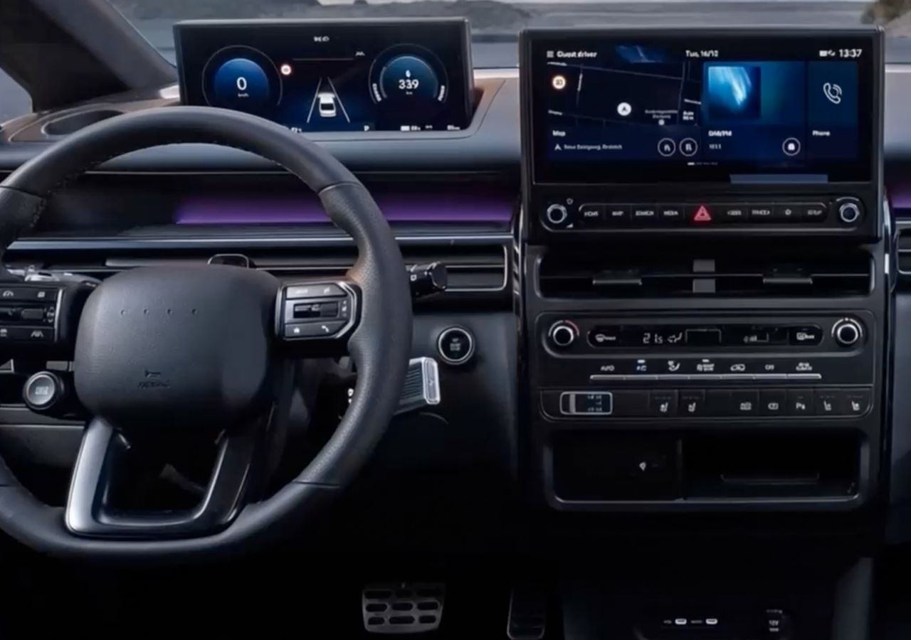 Armaturenbrett des Hyundai STARIA Electric, das doppelte Bildschirme und ein Lenkrad zeigt.