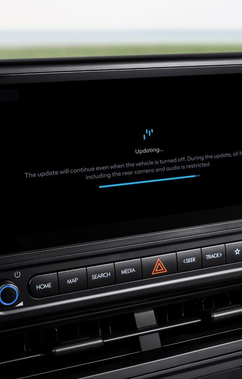 Close-up of the Hyundai STARIA Electric dashboard screen displaying OTA update status and progress bar.