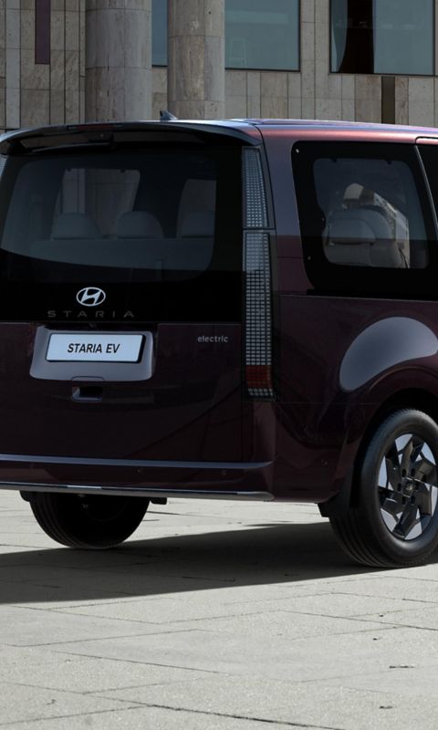 Rear three-quarter view of a parked Hyundai STARIA Electric.