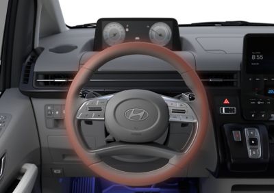 The heated steering wheel inside of the Hyundai STARIA Hybrid multi-purpose vehicle.