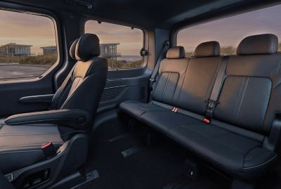 Hyundai STARIA Electric rear seating area featuring a three-person bench and single seat.
