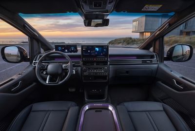 Full Hyundai STARIA Electric interior view showing driver and passenger area at sunset.