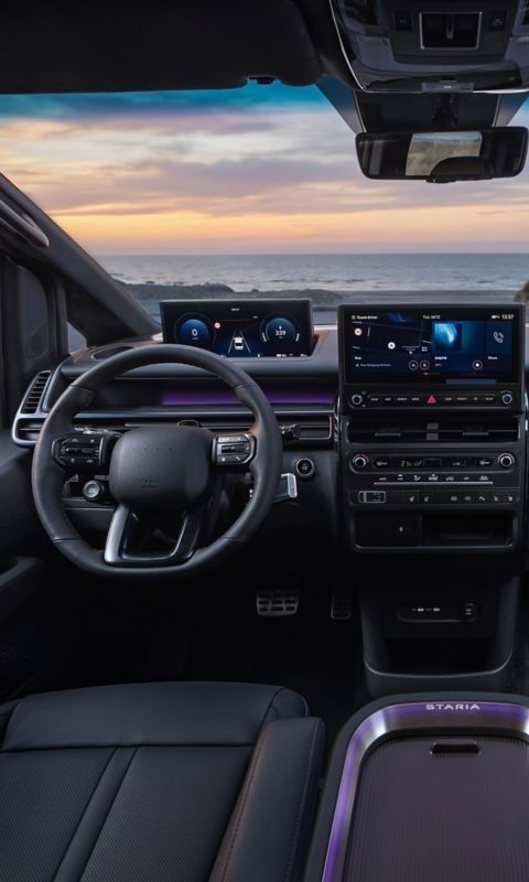 Full Hyundai STARIA Electric interior view showing driver and passenger area at sunset.