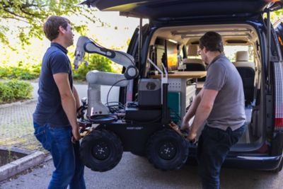 TUM experts loading one of the SVan robots into the vehicle.