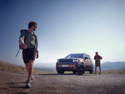 Dos personas hacen footing junto a un TUCSON aparcado.