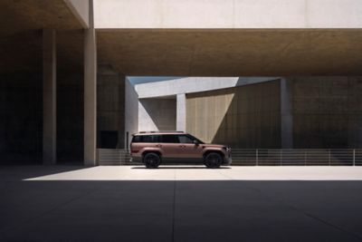 The Hyundai Santa Fe SUV parked between high walls in the sunshine.