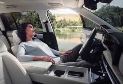 A woman relaxing in the driver's seat of the Hyundai SANTA FE.
