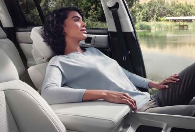 A woman relaxing in the front seat of the SANTA FE Hybrid