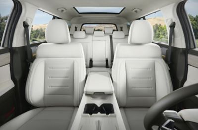 Il SUV da 5 o 7 posti Hyundai SANTA FE parcheggiato tra mura elevate e immerso nella luce del sole