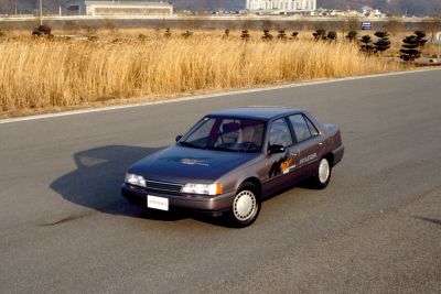 En eldre Hyundai kjører på en vei. Foto.