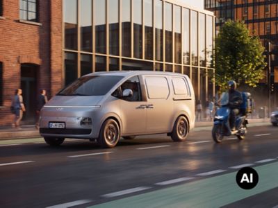 Hyundai Staria Cargo electric driving through a city street alongside urban traffic.