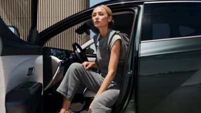 Der Hyundai TUCSON Hybrid von schräg vorne vor einem innerstädtischen Gebäude.