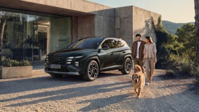 Hyundai TUCSON zaparkovaný vedle budovy.