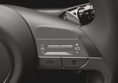  	A woman sitting in the driving seat of the Hyundai TUCSON Hybrid, looking back over her shoulder.