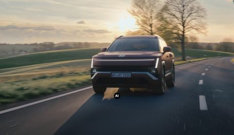 Hyundai TUCSON driving along a road with the sun setting in the background.