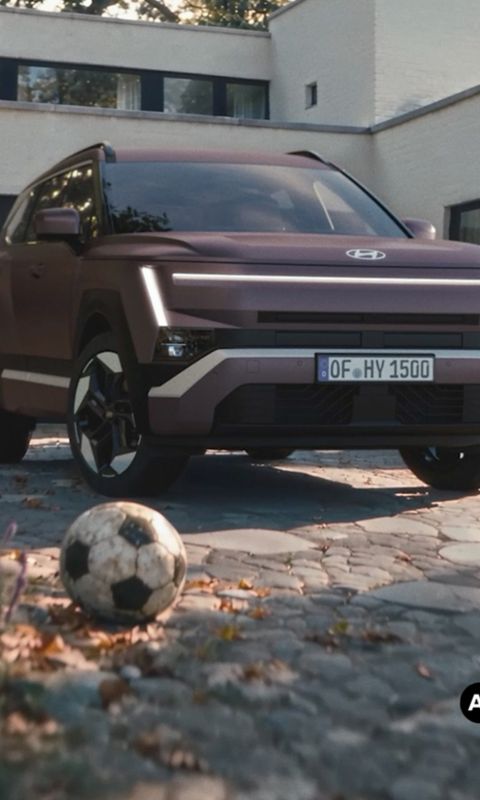 Hyundai TUCSON garé dans une allée avec une maison résidentielle en arrière-plan.