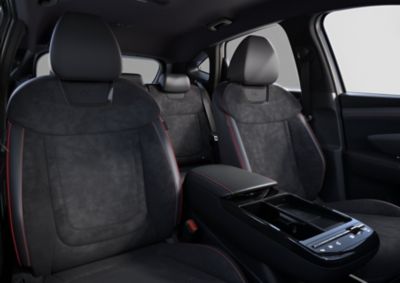 Interieur Hyundai TUCSON N Line met zicht op armsteun, voorstoelen en achterbank.